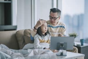 father and ill child at a pediatric telemedicine appointment
