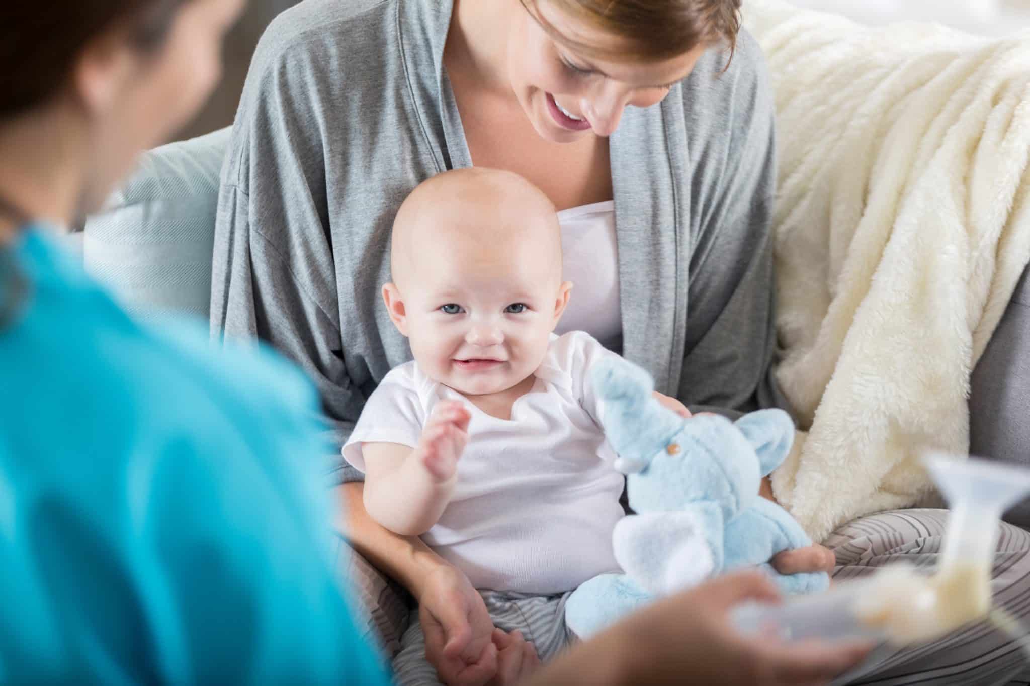 mother holding infant and asking questions to a lactation consultant