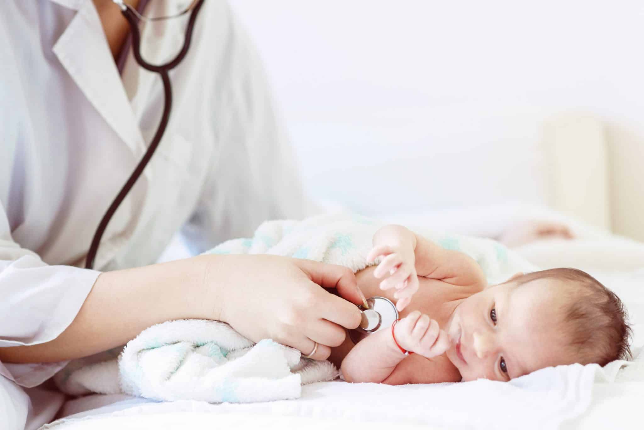 Newborn baby receiving pediatric care from pediatrician.