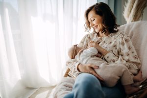 young mother breastfeeding baby in comfortable home